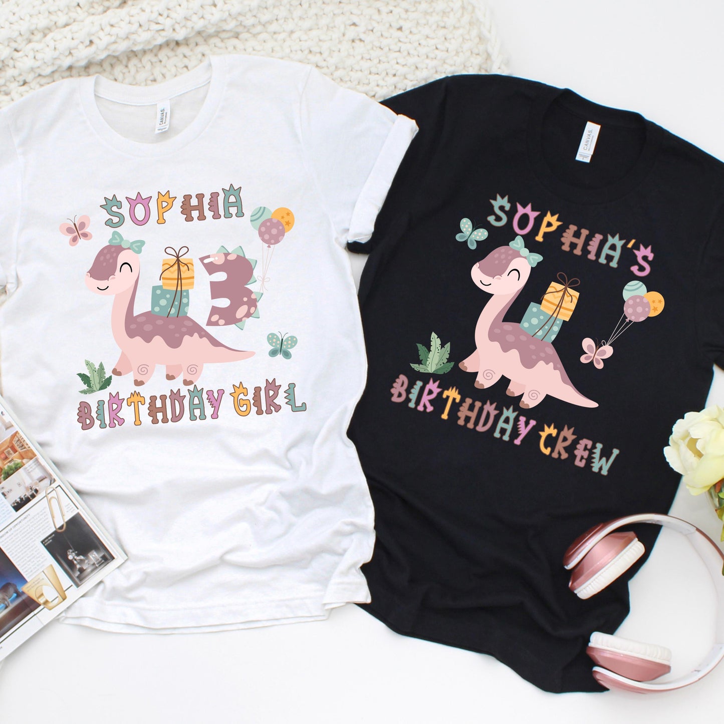 Custom birthday girl t-shirt design featuring a cute pink dinosaur carrying gifts and balloons, surrounded by butterflies and greenery. Includes customizable name and age, with matching "Birthday Girl" and "Birthday Crew" shirt options for family and friends.
