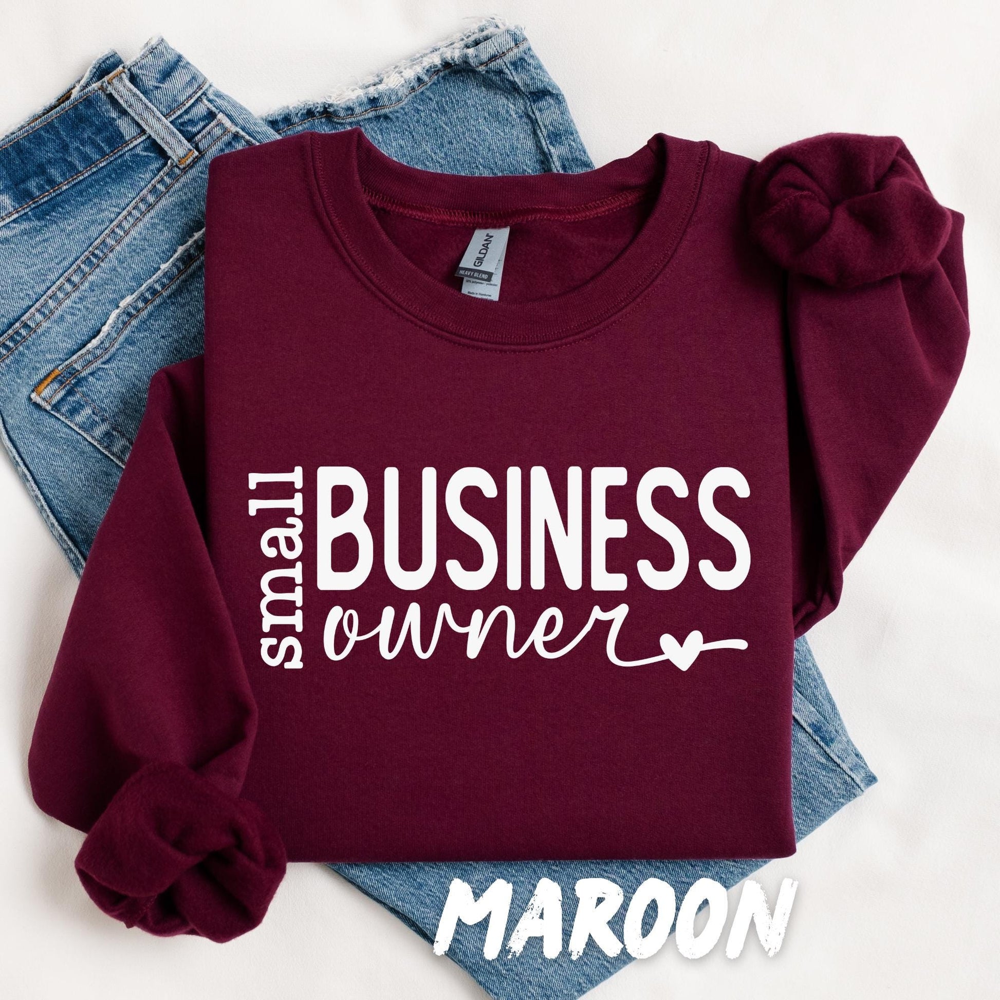 Maroon Gildan sweatshirt folded flat featuring the Small Business Owner design.