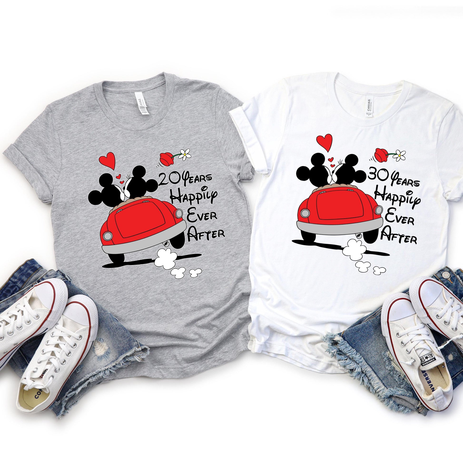 custom anniversary T-shirts laid flat, each with a cartoon design of Mickey and Minnie Mouse kissing in a red car with hearts and flowers above. The gray shirt reads '10 Years Happily Ever After,' and the white shirt reads '8 Years Happily Ever After.' The number of years is customizable.