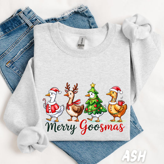 Ash gray unisex sweatshirt featuring four festive cartoon geese dressed as Santa, a reindeer, a Christmas tree, and a holiday goose holding a mug. The phrase “Merry Goosmas” is written below in green and red festive font. Cozy and humorous holiday sweater.