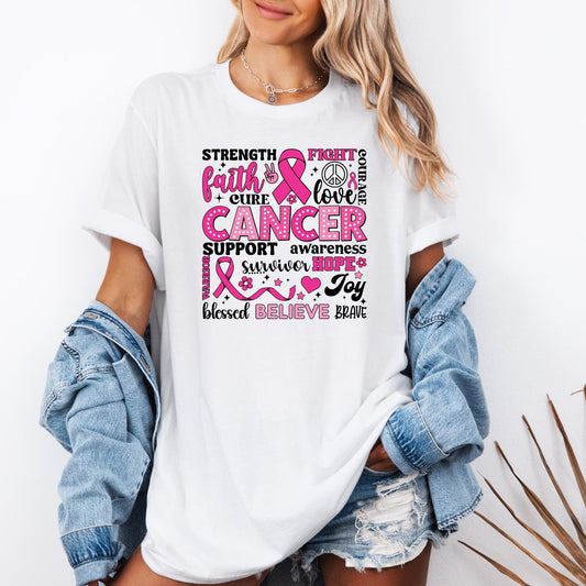 T-shirt with a pink and black breast cancer awareness design featuring words like ‘Strength,’ ‘Faith,’ ‘Cure,’ ‘Support,’ ‘Hope,’ ‘Believe,’ and ‘Brave,’ along with pink ribbons, hearts, flowers, and peace symbols.