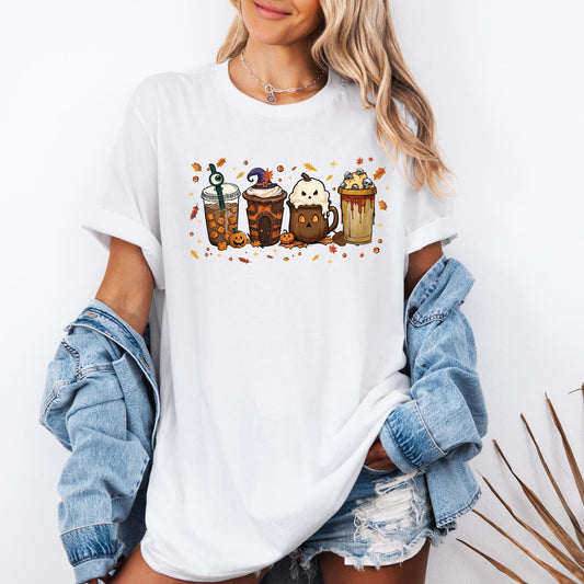 Shirt with a fun Halloween-themed design of five festive drinks, each decorated with spooky details like a witch hat, ghost face, eyeball stirrer, skulls, pumpkins, and dripping syrup, surrounded by autumn leaves and stars.