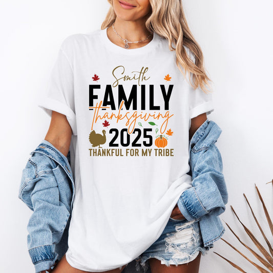 t-shirt with Thanksgiving design that reads ‘Smith Family Thanksgiving 2025 – Thankful For My Tribe’ in bold black and orange lettering. The graphic includes autumn leaves, a turkey silhouette, and a pumpkin illustration, perfect for personalized family holiday gatherings.
