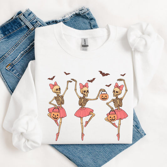 Three cute dancing skeleton ballerinas in pink tutus with bows, holding Halloween pumpkin buckets, surrounded by bats