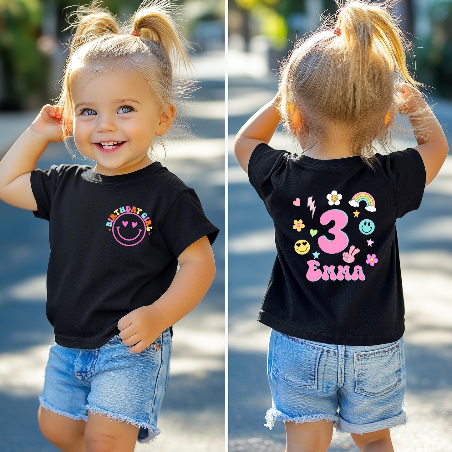 A smiling toddler wearing a black birthday T-shirt with colorful designs. The front of the shirt features a pink smiley face with the words “BIRTHDAY GIRL” above it in rainbow colors. The back of the shirt displays a large number “3,” surrounded by cute doodles like flowers, hearts, stars, a rainbow, and smiley faces, along with a customizable name (e.g., “Emma”). The age and name on the shirt can be personalized.