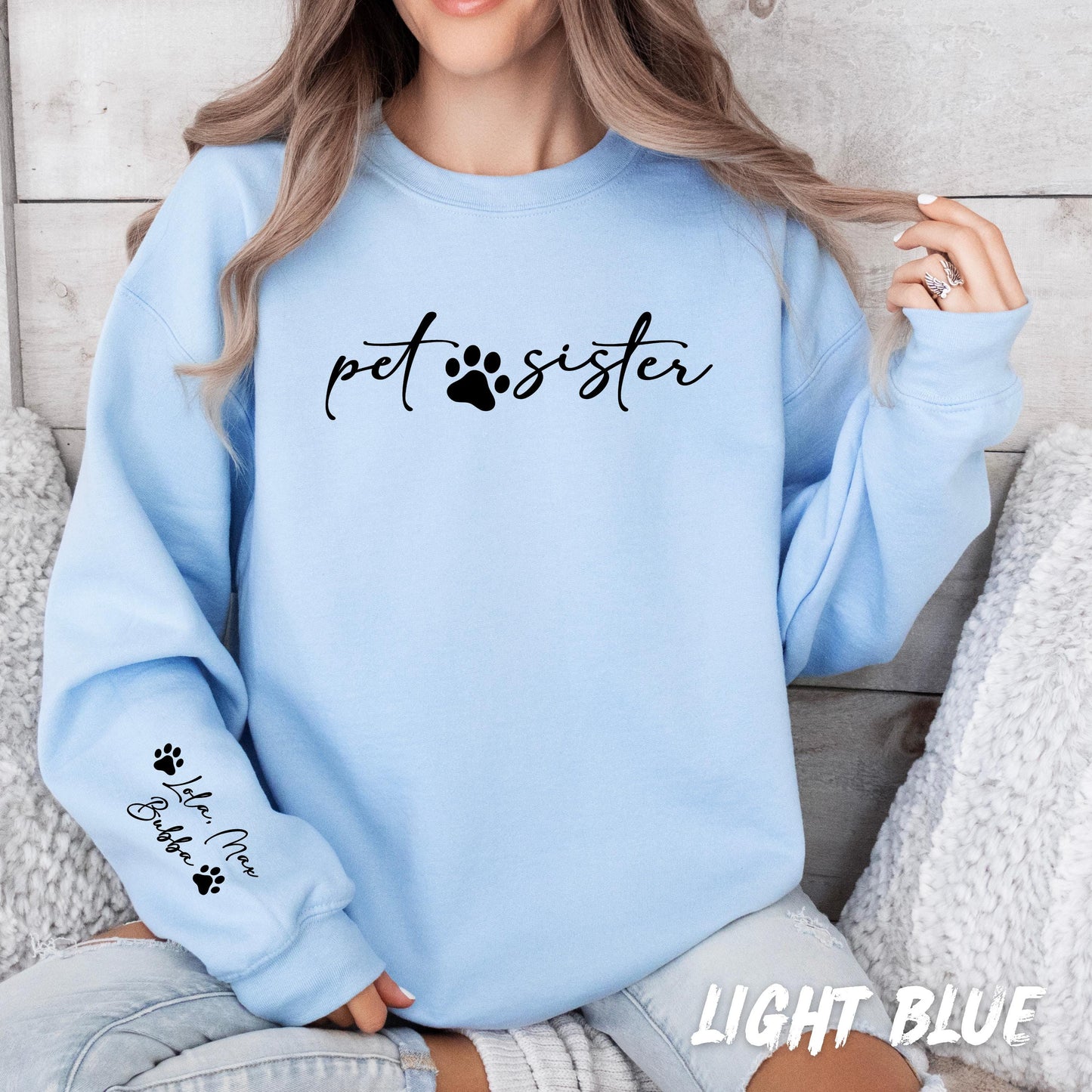pet sister sweatshirt featuring paw print design on the chest with custom text option and personalized pet names on the sleeve. Soft unisex dog lover crewneck perfect for everyday wear or gifting.
