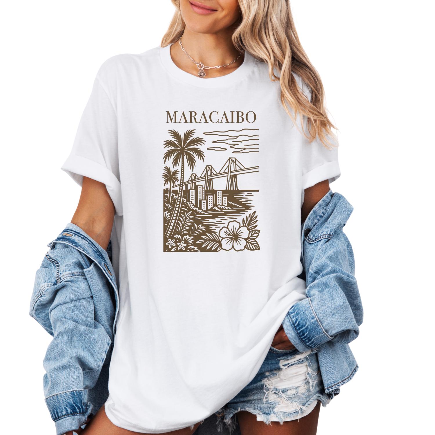 graphic t-shirt featuring a Maracaibo, Venezuela city illustration with palm trees, bridge, skyline, and tropical floral design.