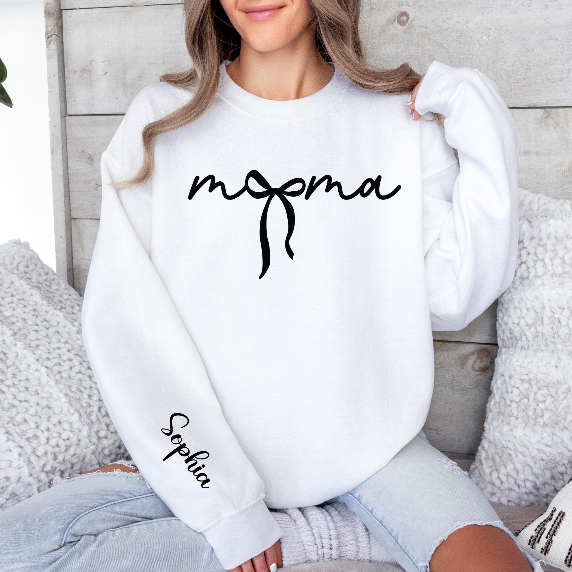 mama sweatshirt with elegant handwritten script and bow design on the front, featuring a personalized child’s name printed on the sleeve, minimalist and modern mom apparel.