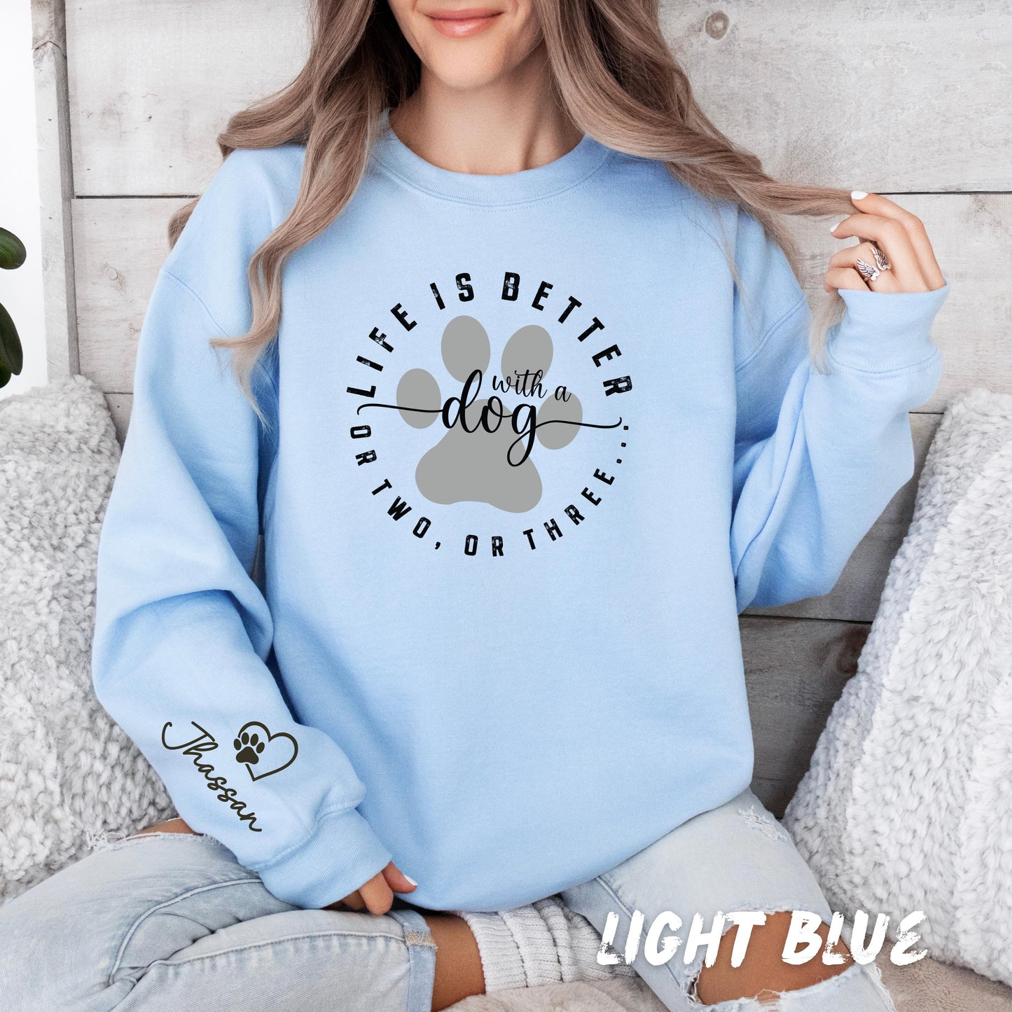 Cozy white sweatshirt for dog lovers with personalized sleeve name and cute paw artwork