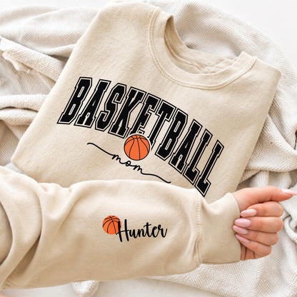 Basketball mom sweatshirt with bold varsity lettering and basketball graphic, personalized sleeve name design, cozy sports mom crewneck