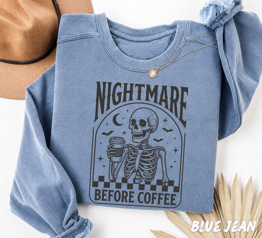 Comfort Colors 1717 Blue Jean garment-dyed t-shirt featuring a vintage gothic "Nightmare Before Coffee" skeleton holding a coffee cup with bats, moon, stars, and spooky retro artwork.