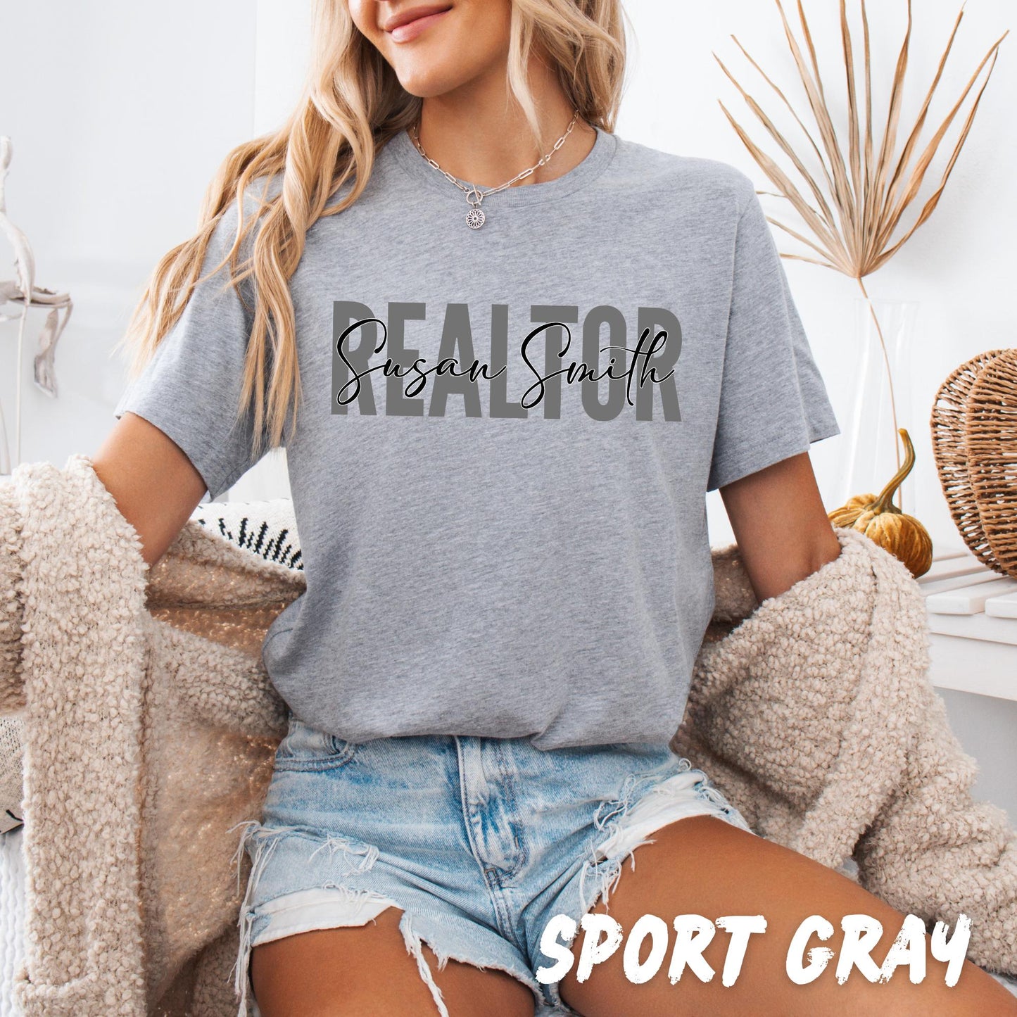 Female real estate agent wearing personalized Realtor T-shirt paired with casual jeans, stylish custom business apparel for everyday wear.