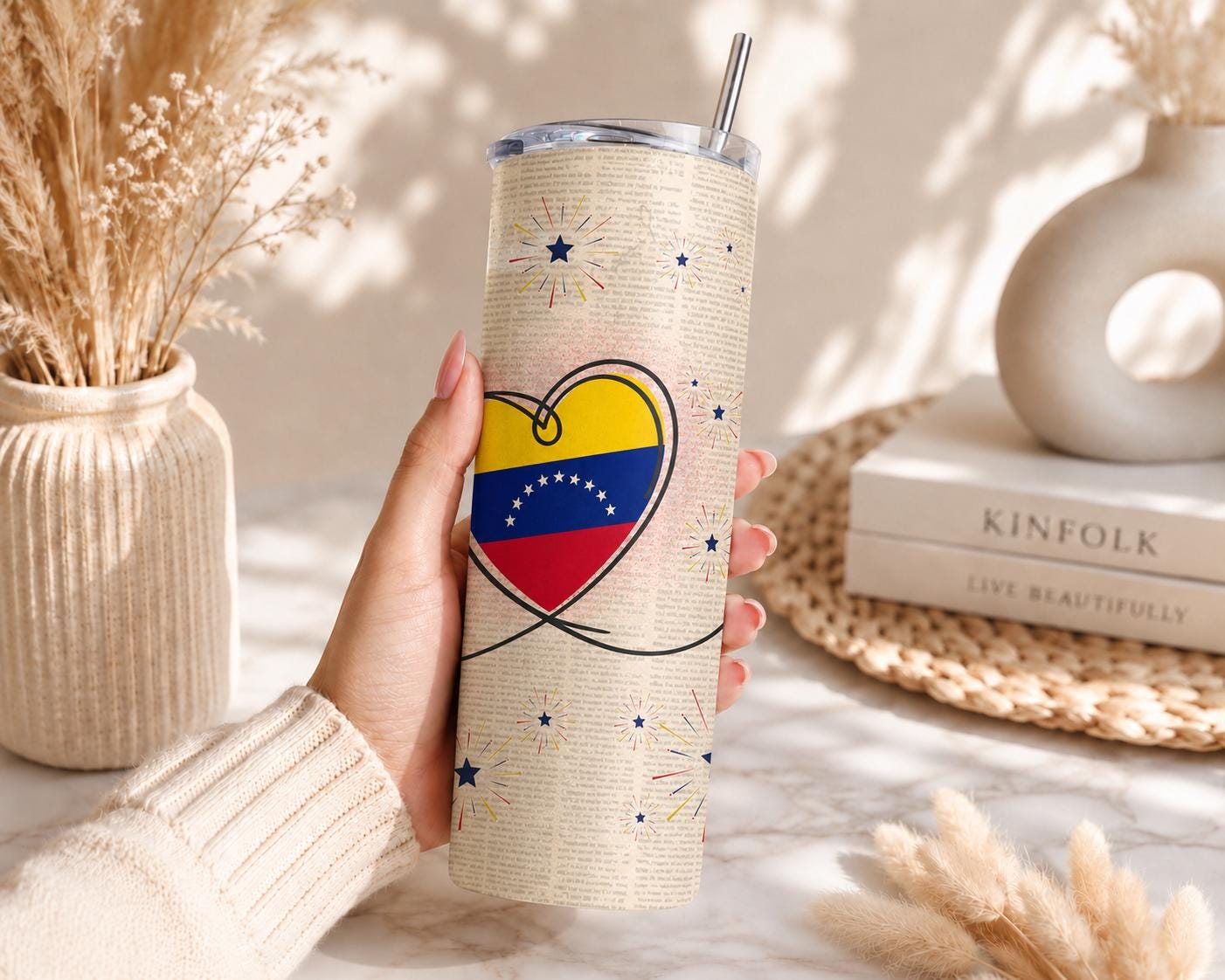Lifestyle photo of a Venezuelan insulated coffee tumbler with lid and straw displayed in a cozy home setting.