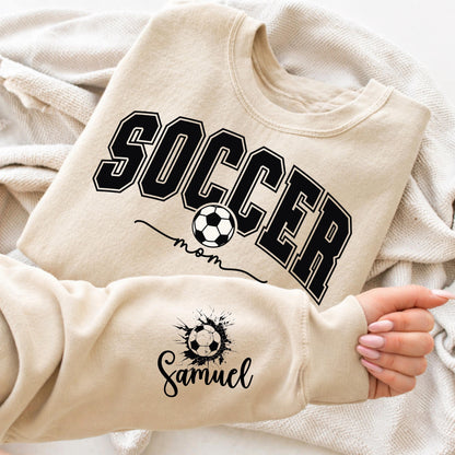 Sand Gildan crewneck sweatshirt featuring a personalized Soccer Mom design with customizable player name, perfect for game days and soccer season.