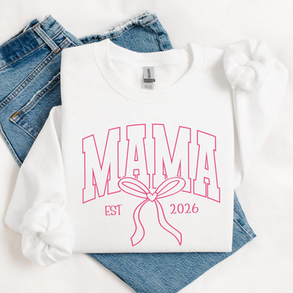 White Gildan crewneck sweatshirt featuring a pink varsity-style "Mama" design with a coquette bow, perfect for Mother's Day and everyday mom style. Custom EST.