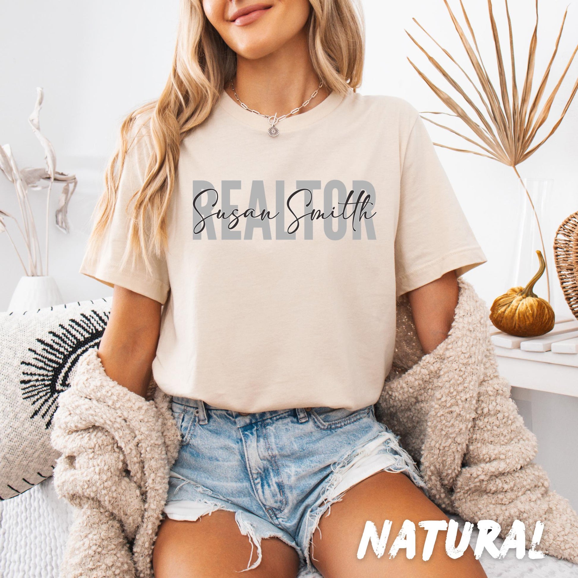 Custom Realtor shirt with personalized name printed across the chest in layered typography, unisex softstyle T-shirt available in multiple colors.