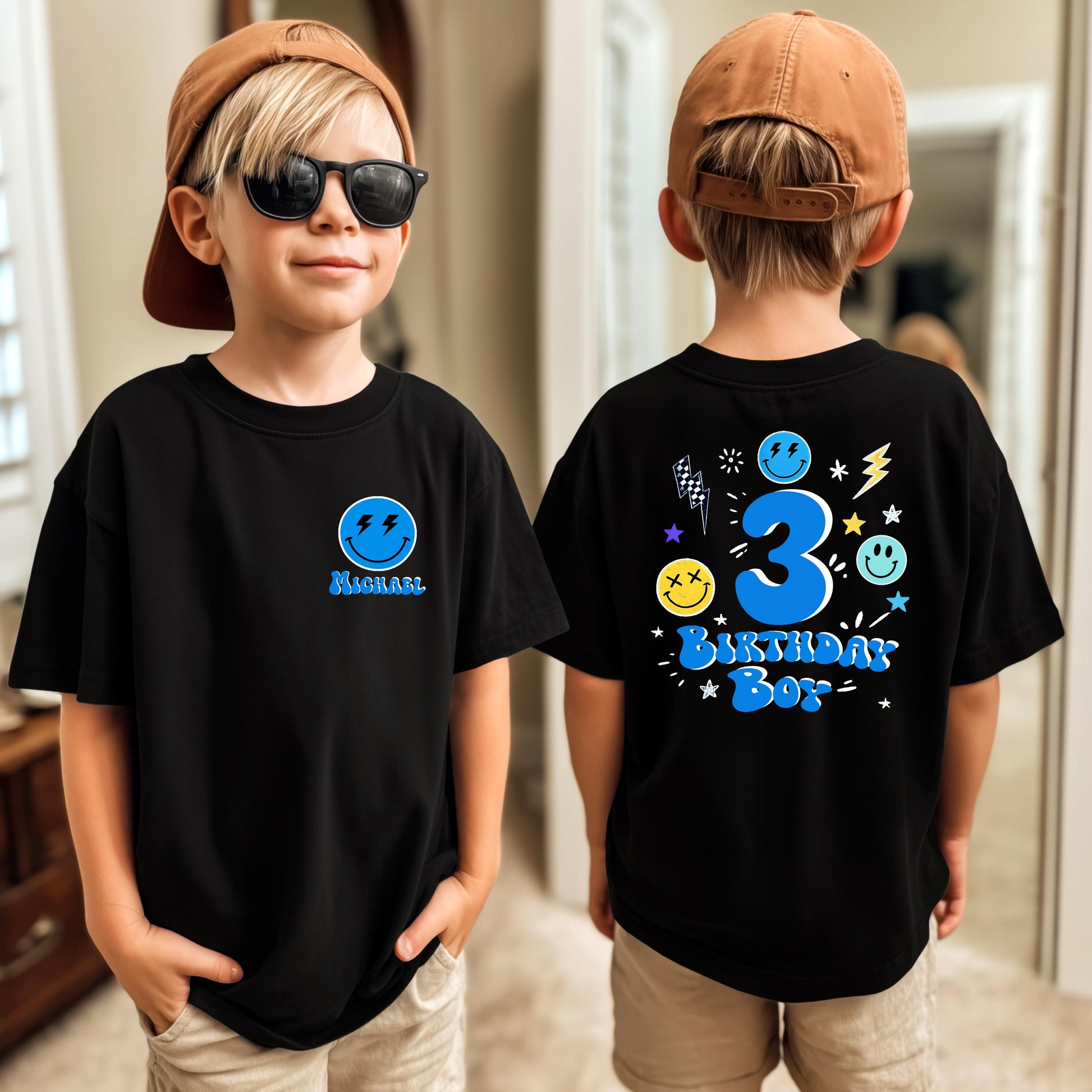 Young boy wearing a personalized black birthday shirt with a custom name on the front and a colorful birthday design with customizable age on the back.