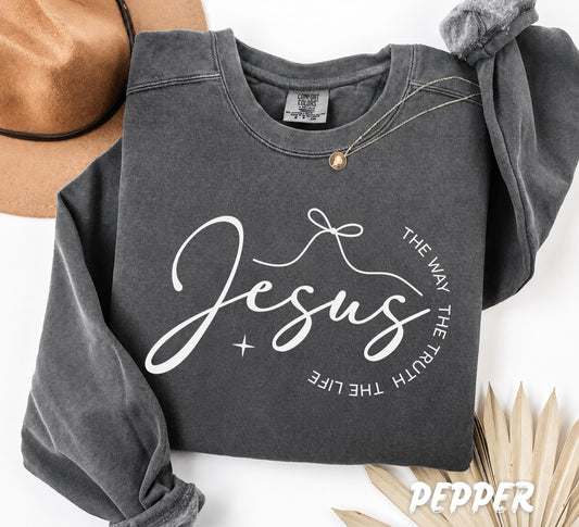 Folded Pepper Comfort Colors crewneck sweatshirt featuring a minimalist Christian "Jesus" typography design with "The Way The Truth The Life" in a modern circular composition.