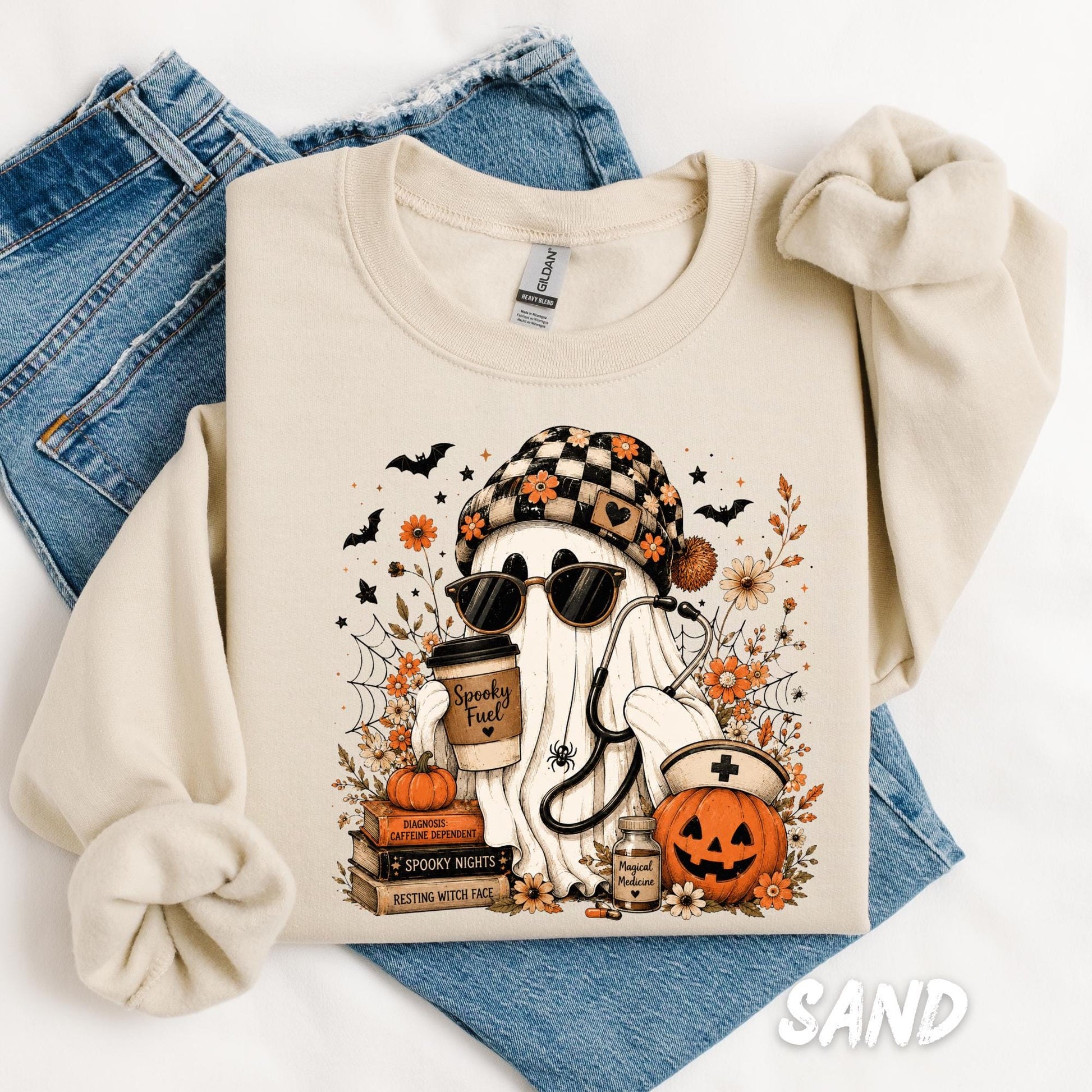 Cute Gildan sweatshirt featuring a ghost nurse holding coffee with pumpkins, stethoscope, books, and fall floral accents for Halloween.