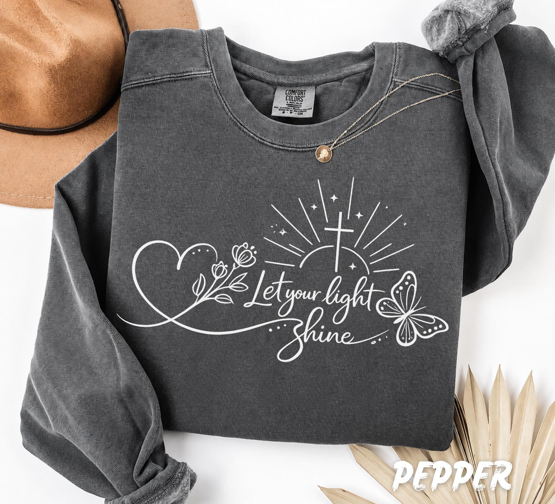 Close up of Christian Bible verse design with cross butterfly flowers and Let Your Light Shine typography