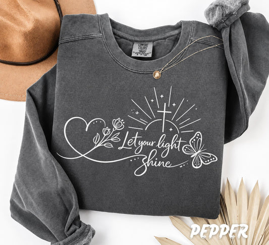 Close up of Christian Bible verse design with cross butterfly flowers and Let Your Light Shine typography