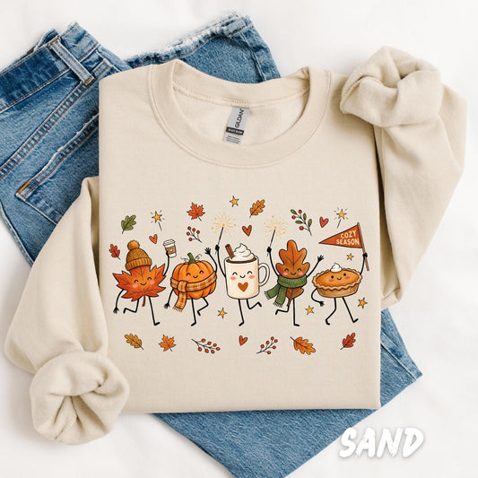 Sand Gildan crewneck sweatshirt featuring cute autumn characters including smiling leaves, pumpkin, coffee, pie, and cozy season illustration for fall and Thanksgiving.