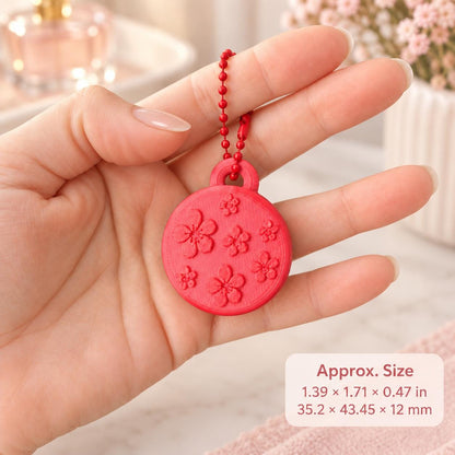 Red floral ring holder keychain displayed in an adult hand for size reference, with measurements shown in inches and millimeters.