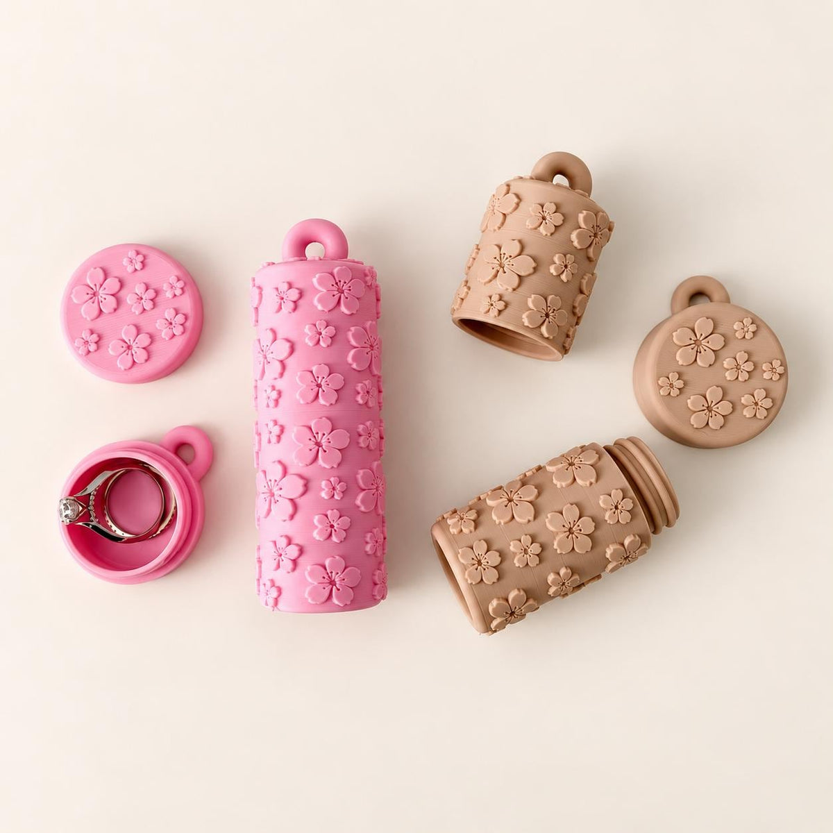 Matching pink and beige floral lip balm holders and round ring keeper keychains displayed on a warm ivory background.